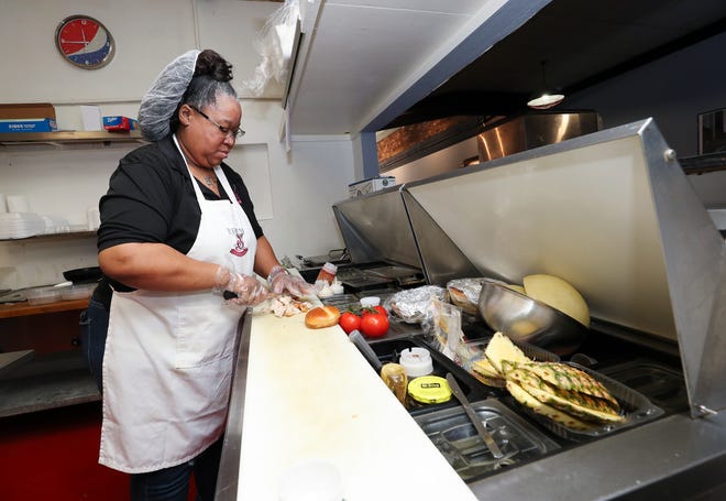 LaToya Bradley, owner of the Brew & Sip Coffee Bar and Cafe makes the Culture sandwich at their new location in downtown Louisville, Ky. on May 9, 2022.  