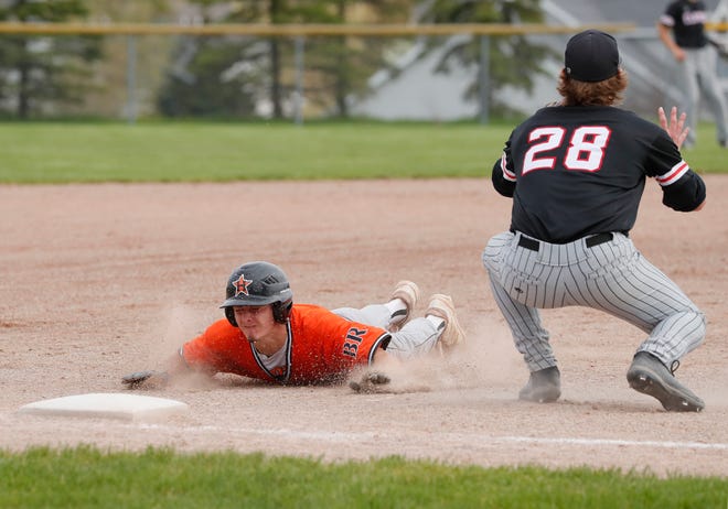 Hudson's Anthony Arrendondo slides into third while Clinton's Ethan Herington prepares for the ball to come in during Tuesday's doubleheader at Clinton.