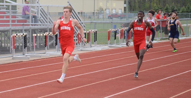Isaac Smith (left) and New Boston Huron teammate Antonio Talley lead the pack in the boys 200 meters Tuesday.