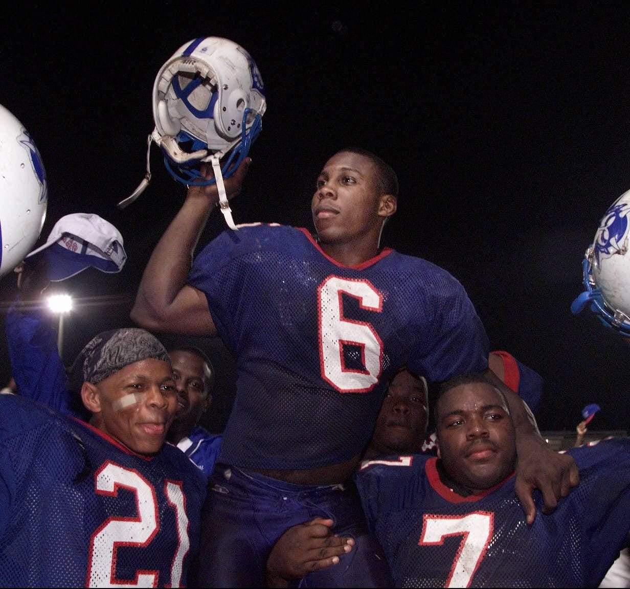 Jermaine Sanders (21) and Desmond Rickets (7) hoist Anquan Boldin after a Pahokee win in December 1998. Greg Lovett/Palm Beach Post