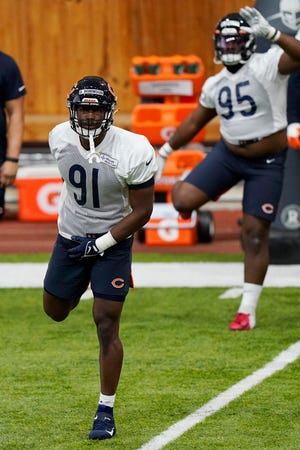 Chicago Bears defensive end Dominique Robinson (91) warms up with teammates during the team's rookie minicamp at Halas Hall in Lake Forest, Ill., Friday, May 6, 2022.
