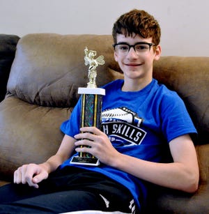 Andrew Yeager sits at home in Doylestown showing off the trophy he received in March when he won the Akron Beacon Journal's Regional Spelling Bee. It was Yeager's second consecutive victory in the bee.