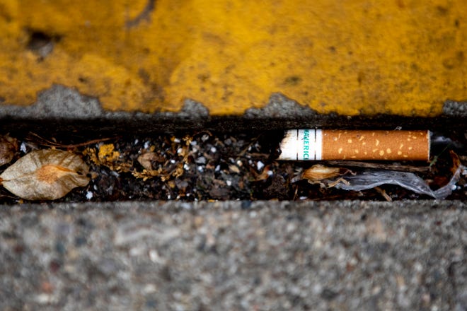 A Maverick Menthol cigarette but rests on the ground in Lower Price Hill on Wednesday, May 11, 2022. 