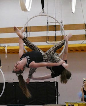 A pair of performers show their skills on an aerial ring.
