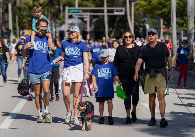 People walk their dogs along Flagler Drive during Peggy Adams' 21st Annual Animal Walk on February 19.  The group will hold a Christmas ball on December 8th.