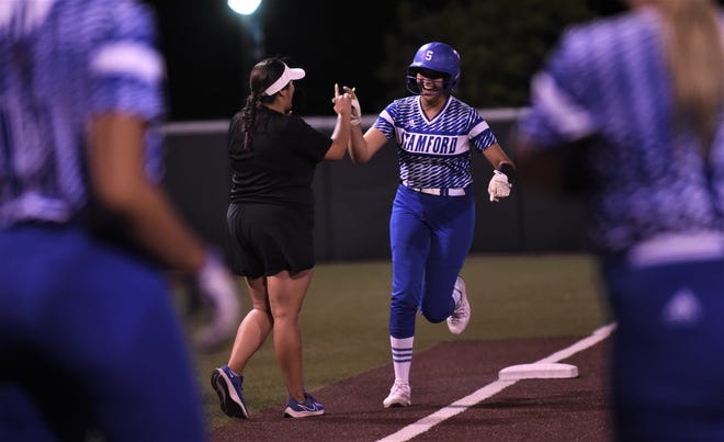 Stamford senior Citlaly Gutierrez, right, gets a high-five from coach Cyndi Herrera after hitting her third home run of the game, a three-run shot, to cap a six-run sixth inning in Game 2 against Haskell.