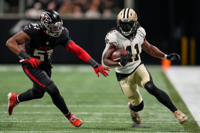 Alvin Kamara tries to run away from an Atlanta defender 