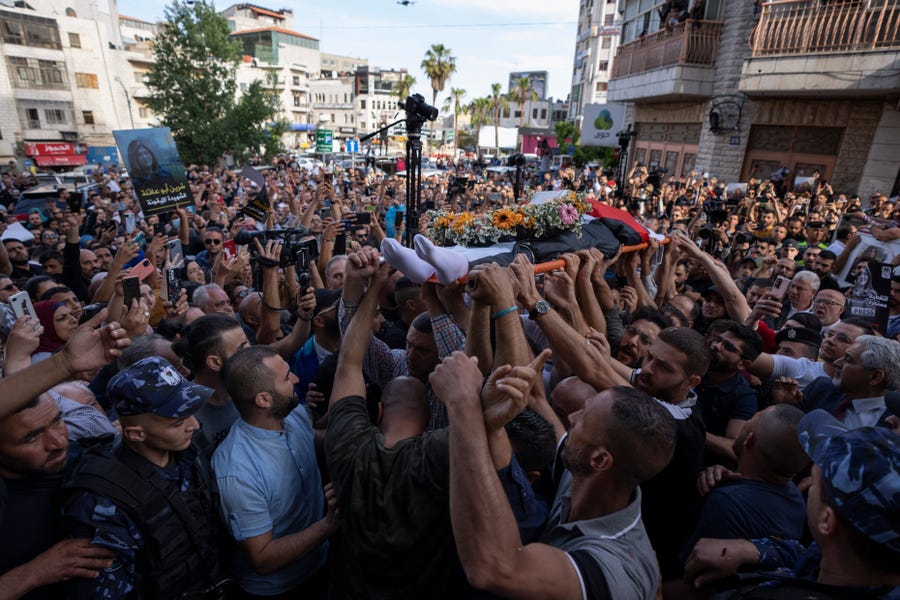 Palestinian mourners carry the body of veteran Al Jazeera journalist Shireen Abu Akleh toward the Al Jazeera office for her fellow journalists to pay their respects, in the West Bank city of Ramallah, Wednesday, May 11, 2022.