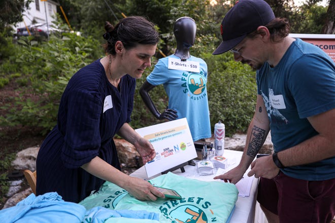 Kam McEvoy, left, speaks to Michael Kaurich at the launch party for Safe Streets Austin, a nonprofit focused on making the city more pedestrian- and cyclist-friendly.  McEvoy, an administrative assistant for the organization, sold shirts and stickers and signed up visitors for memberships.  Residents and city leaders met at the Tudor House at Pease Park on May 12.