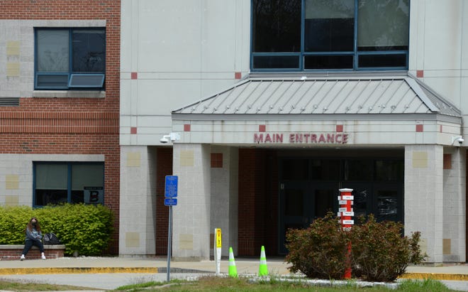 In May, a lone student waited outside the main entrance to Barnstable High School which closed early on a Friday morning because of staff shortages brought on by COVID cases. Steve Heaslip/Cape Cod Times