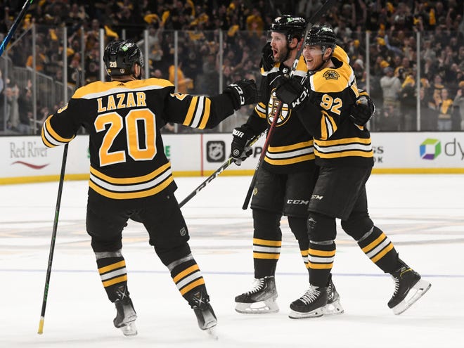 Bruins defenseman Derek Forbort (28) celebrates with left wing Tomas Nosek (92) and center Curtis Lazar (20) after scoring a goal against the Hurricanes during the third period.