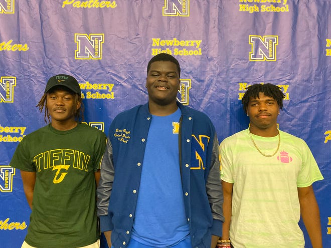 Newberry's Joe Carter (left), Lennie Boykin (middle) and Te'Veon Tate (right) all signed athletic scholarships on May 13 from Newberry High School's auditorium.