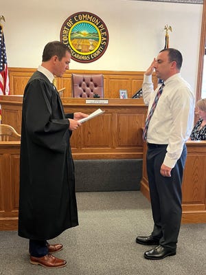 Tuscarawas County Probate Judge Adam Wilgus administers the oath of office to Shane Gunnoe on Friday after choosing him as interim mayor of Dover.
