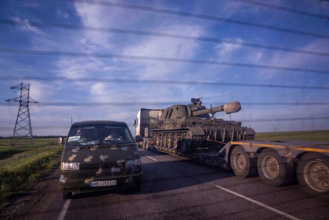 Sebuah truk mengangkut platform dengan kendaraan artileri self-propelled Ukraina di wilayah Donetsk, Ukraina, pada Kamis, 12 Mei 2022.