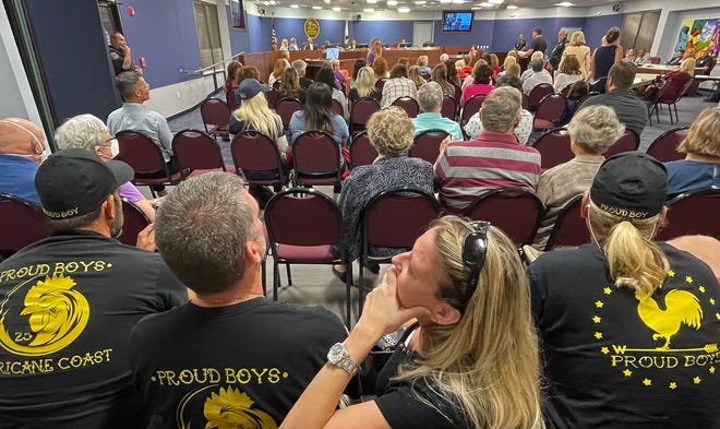 Individuals wearing shirts with "Proud Boys" on the back sit at a Sarasota School Board meeting May 13.