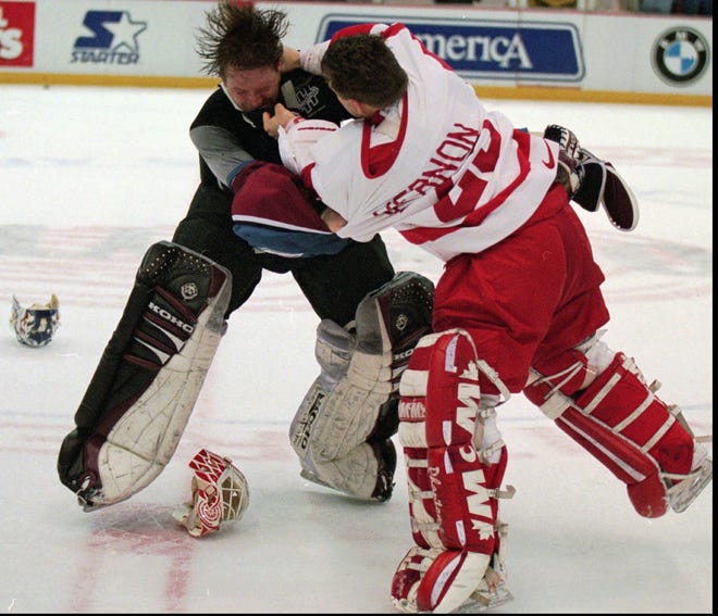 Colorado Avalanche goaltender Patrick Roy, left, takes a punch from Detroit Red Wings goaltender Mike Vernon during the first period brawl in Detroit on March 26, 1997.