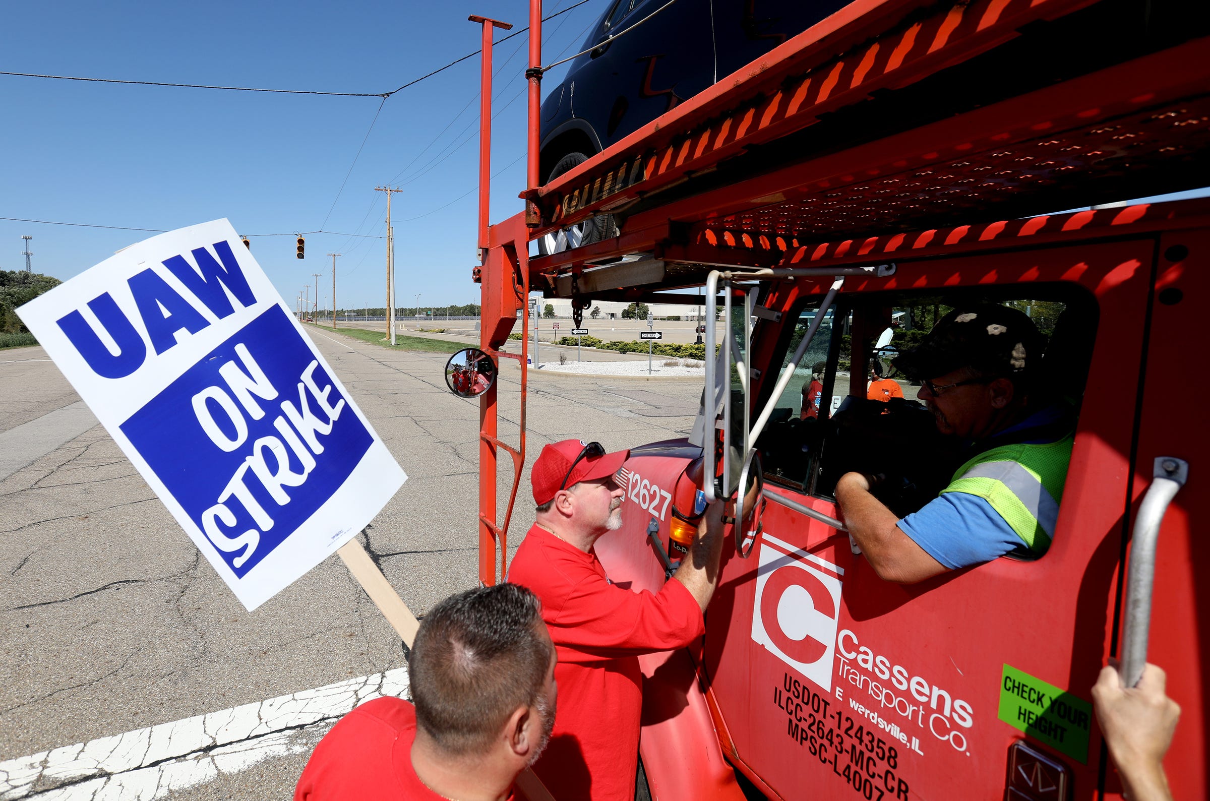 UAW members stop to talk with car transports traveling down Hallock-Young Road in front of the empty Lordstown plant that was moving GM cars made in Mexico in front of their house in Lordstown, Ohio, on Sept. 18, 2019.