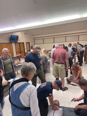 Firefighters and emergency responders help train volunteers in how to do CPR and operate an AED machine in case they're ever called to help with a sudden cardiac arrest patient.