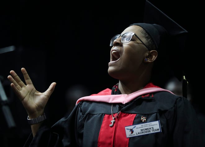 Graduate Jayla Hartsfield wears a pin - like many in attendance - showing support for the women's lacrosse team as she sings with the University Choir during Delaware State University's 2022 commencement ceremonies in Memorial Hall, Saturday, May 14, 2022.