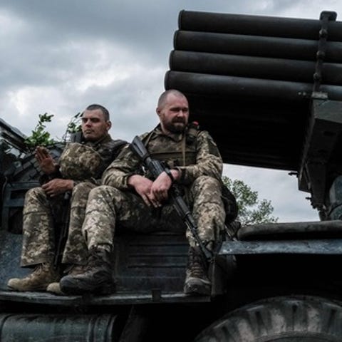 Ukrainian soldiers ride on a moving truck-mounted 