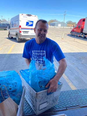 Dan Bruckner, letter carrier coordinator for the annual Stamp Out Hunger food drive, unloads a crate of food Saturday at the Aberdeen post office. More than 17,000 pounds of food were collected for local pantries.
