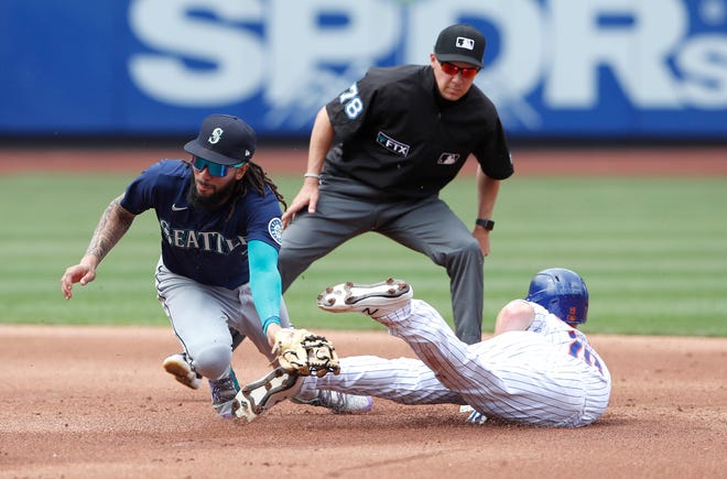 Seattle Mariners shortstop J.P. Crawford (3) tags out New York Mets left fielder Mark Canha (19) at second base during the first inning of a baseball game Sunday, May 15, 2022, in New York.
