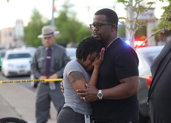 A couple grieve outside the Tops Friendly Market, in Buffalo, New York, where 10 people were killed and three others injured in a shooting May 14.