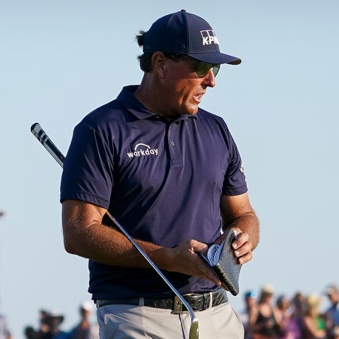 Phil Mickelson prepares to putt on the 18th green 