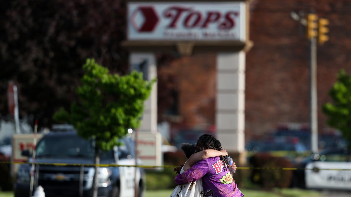 People hug outside the scene after a shooting at a supermarket on Saturday, May 14, 2022, in Buffalo, N.Y.