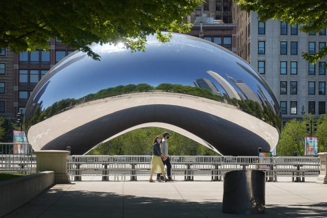 Visitors walk past the Cloud Gate, also known as "The Bean," sculpture in Millennium Park on June 15, 2020, in Chicago