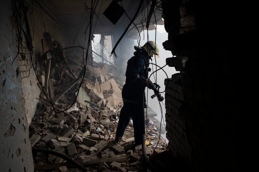 A Ukrainian firefighter works inside a destroyed cultural center in Derhachi, eastern Ukraine, on May 15, 2022. A Russian airstrike destroyed the venue on May 12.