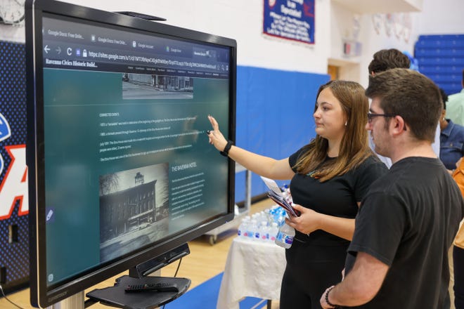 Visitors to the Honors Ravenna Civics class symposium explore Ravenna history set-up on a large touchscreen display as part of the event held Monday at Ravenna High School.