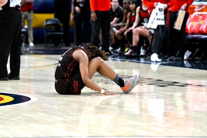 Indiana rookie and No. 2 pick NaLyssa Smith sits on the court after spraining her ankle as the Indiana Fever host the Atlanta Dream at Gainbridge Fieldhouse in Indianapolis on May 15, 2022.