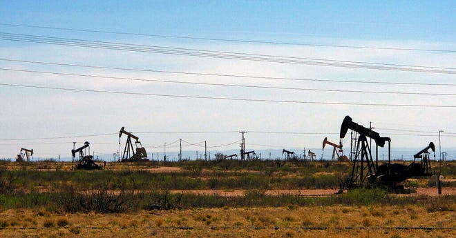 Oil rigs stand in the Loco Hills field along U.S. Highway 82 in Eddy County, near Artesia, one of the most active regions of the Permian Basin. Government budgets are booming in New Mexico. The reason behind the spending spree — oil. New Mexico is the No. 2 crude oil producer among U.S. states and the top recipient of U.S. disbursements for fossil fuel production on federal land.