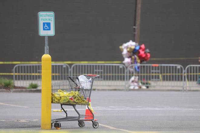 A grocery cart in the parking lot of the store is full of police line tape. FBI collect evidence and take measurements from inside the Tops Friendly Market store in Buffalo, New York on May 16.