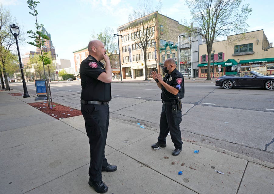 MSOE Public Safety officers investigate the scene of a shooting near the corner of North Water Street and East Juneau Avenue in Milwaukee, Saturday, May 14, 2022, where multiple were shot and injured late Friday in Milwaukee's downtown bar district after the Milwaukee Bucks playoff game.
