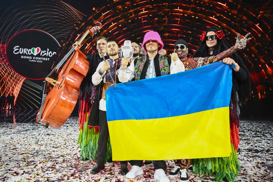 Members of the band "Kalush Orchestra" pose onstage with the winner's trophy and Ukraine's flags after winning on behalf of Ukraine the Eurovision Song contest 2022 on May 14, 2022 at the Pala Alpitour venue in Turin.