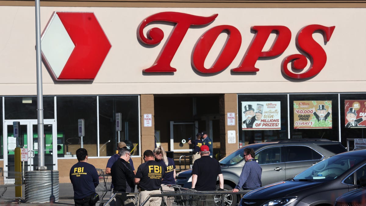 ]Police and FBI agents continue their investigation of the shooting at Tops market on May 15, 2022 in Buffalo, New York.