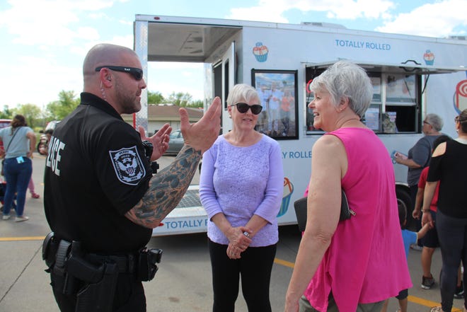 Perry Det. Josh Sienkiewicz talks with Brenda Swigert and Vicki Klein during the Perry Police Appreciation Day on Monday, May 16 in the Perry Hy-Vee parking lot.
