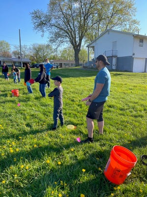 Parents and children learn how to throw a disc before playing the new nine-hole Leopardville Disc Golf Course that sits adjacent to Louisville Middle School. The course, which sits on school district-owned property, is open to the public.