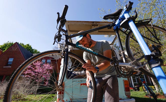 Brian Latulippe, 41, of Royal Oak, works at turning the spokes on the bike of Dave Assemany, of Pleasant Ridge, on May 13, 2022. Latulippe owns Little Bus Bikes, a mobile bike repair he started in 2020. He travels around the Royal Oak, Pleasant Ridge, and Ferndale area in a 1974 VW Bus and estimates he repairs 75 to 80 bikes a week in the driveways or streets of clients and charges $60 for basic tuneups.