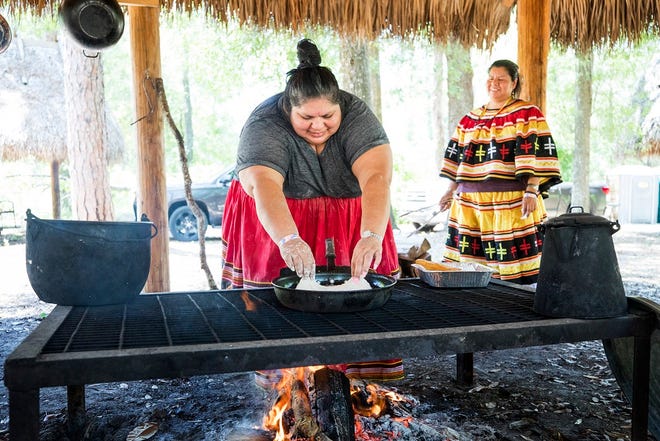 Charlotte Burgess, left, and Janelle Robinson cook frybread in the Seminole Family Camp, Saturday during the Florida Folk Festival at Stephen Foster State Park.

COLIN HACKLEY PHOTO