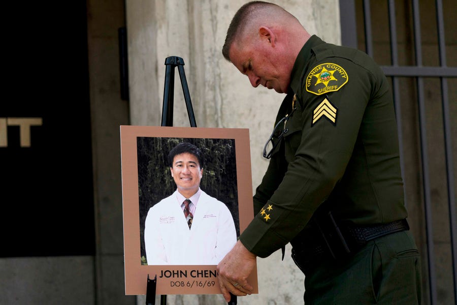 Orange County Sheriff's Sgt. Scott Steinle displays a photo of Dr. John Cheng, who was killed on May 15, 2022, at  the Geneva Presbyterian Church in Laguna Woods, Calif.