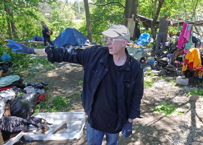 Homeless advocate Sage Lewis points out details of his newest homeless camp on his East Akron property May 17 in Akron.