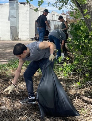 Raymond Rodriguez Martinez picks up garbage Wednesday as part of the Aberdeen Christian School Cleanathon community service event.