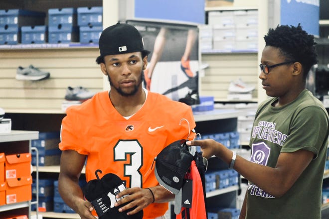 Lelan Wilhoite helps a youth athlete shop at Academy Sports + Outdoors, May 18, 2022