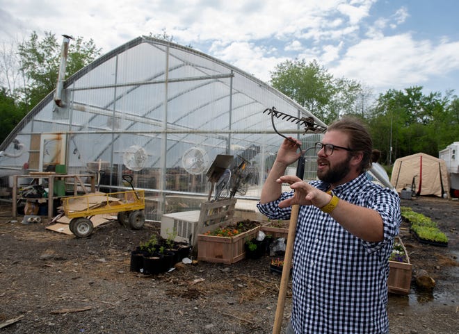 Alex Ross, owner of Moon Farm, stands in front of his greenhouse on the property in Diamond.