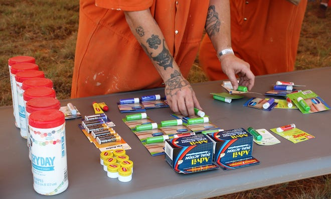 Taylor County inmates help set up a tent where bottled water and other supplies, such as lip balm and wipes, could be picked up by firefighters and volunteers assisting with the Mesquite Heat Fire Thursday.