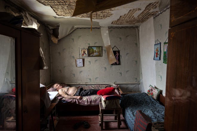 Olexiy Pshenychnykh, 85, beristirahat di rumahnya yang rusak akibat perang di timur Kharkiv pada 18 Mei 2022 di Vilkhivka, Ukraina, yang hingga saat ini diduduki oleh pasukan Rusia.  Para manula di kota itu bergantung pada bantuan kemanusiaan, karena pembayaran pensiun bulanan mereka dari pemerintah ditangguhkan karena pertempuran.