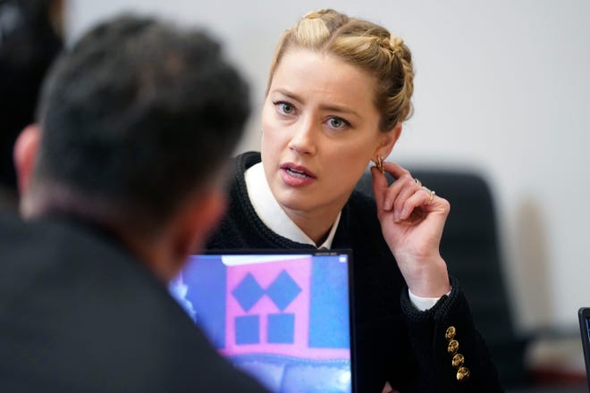 Aktor Amber Heard berbicara dengan anggota tim hukumnya di ruang sidang di Fairfax County Circuit Courthouse di Fairfax, Va., Kamis, 19 Mei 2022.
